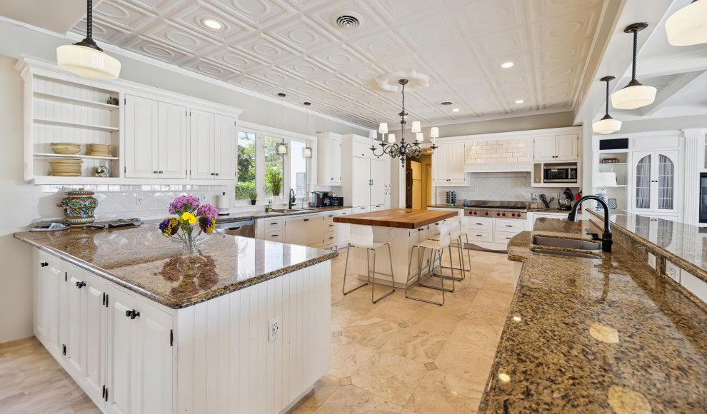 Design ideas for an expansive contemporary u-shaped separate kitchen in Tampa with a drop-in sink, shaker cabinets, white cabinets, granite benchtops, brown splashback, granite splashback, stainless steel appliances, porcelain floors, multiple islands, beige floor and brown benchtop.