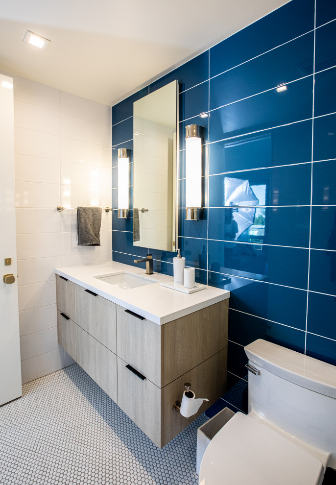 This is an example of a large midcentury kids bathroom in Salt Lake City with flat-panel cabinets, light wood cabinets, an alcove shower, blue tile, white walls, mosaic tile floors, quartzite benchtops, orange floor, a hinged shower door, white benchtops, a single vanity and a floating vanity.