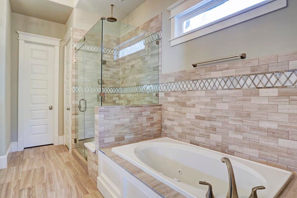 This is an example of a mid-sized traditional master bathroom in Houston with an undermount sink, recessed-panel cabinets, white cabinets, granite benchtops, a drop-in tub, an open shower, a two-piece toilet, brown tile, cement tile, beige walls, porcelain floors, beige floor and a hinged shower door.