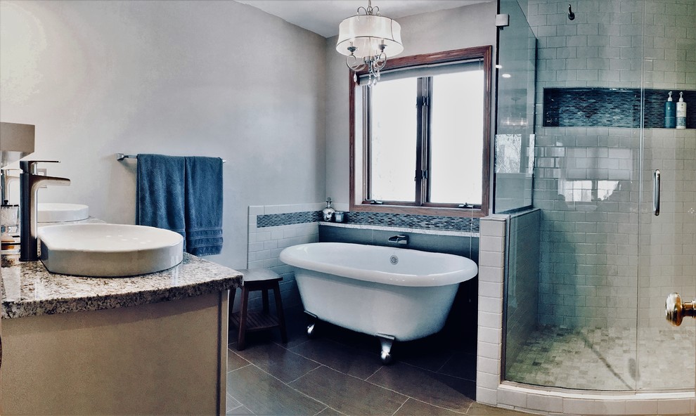 Example of a transitional master multicolored tile and mosaic tile porcelain tile and brown floor freestanding bathtub design with shaker cabinets, white cabinets, a vessel sink, quartz countertops, a hinged shower door and multicolored countertops