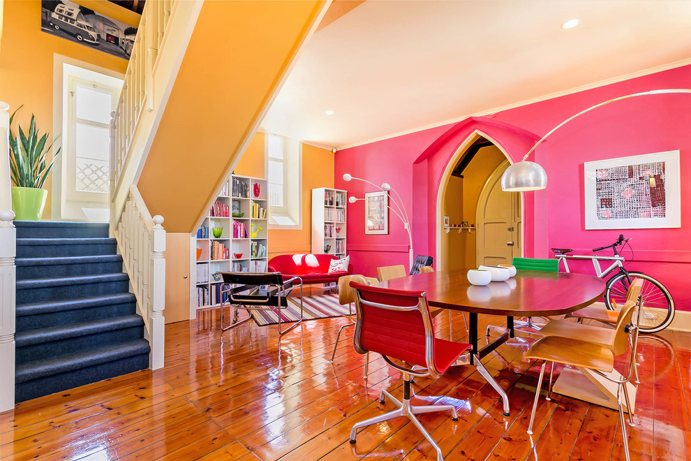 Large eclectic open plan dining in Adelaide with multi-coloured walls and light hardwood floors.