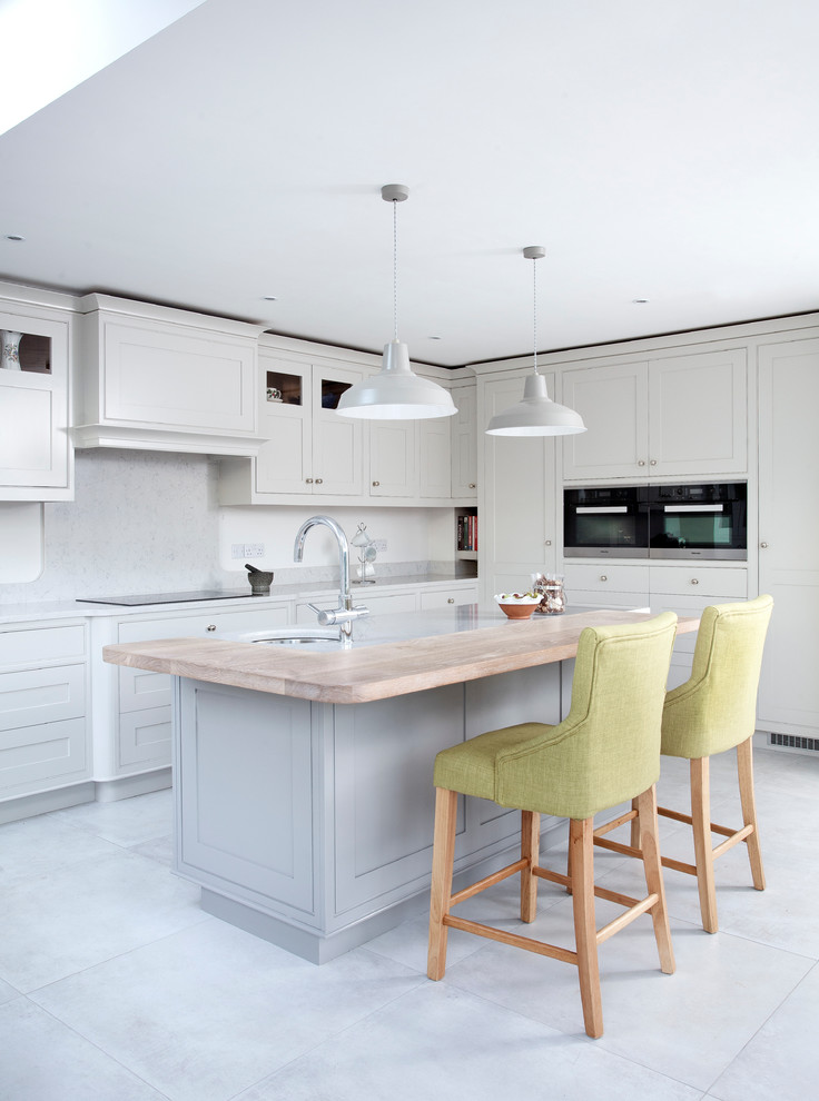 Photo of a mid-sized transitional u-shaped kitchen in Dublin with an undermount sink, shaker cabinets, grey cabinets, grey splashback, ceramic floors and with island.
