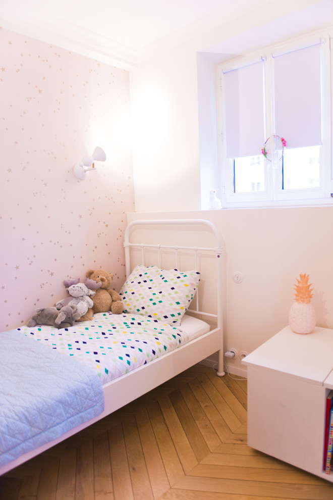 Imagen de dormitorio infantil de 4 a 10 años actual con paredes rosas, suelo de madera clara, suelo beige y papel pintado