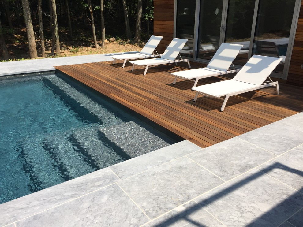 Inspiration for a large backyard stone and rectangular aboveground pool remodel in New York