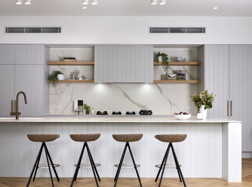 Inspiration for a contemporary galley kitchen in Brisbane with grey cabinets, grey splashback, panelled appliances, light hardwood floors, with island, beige floor and white benchtop.