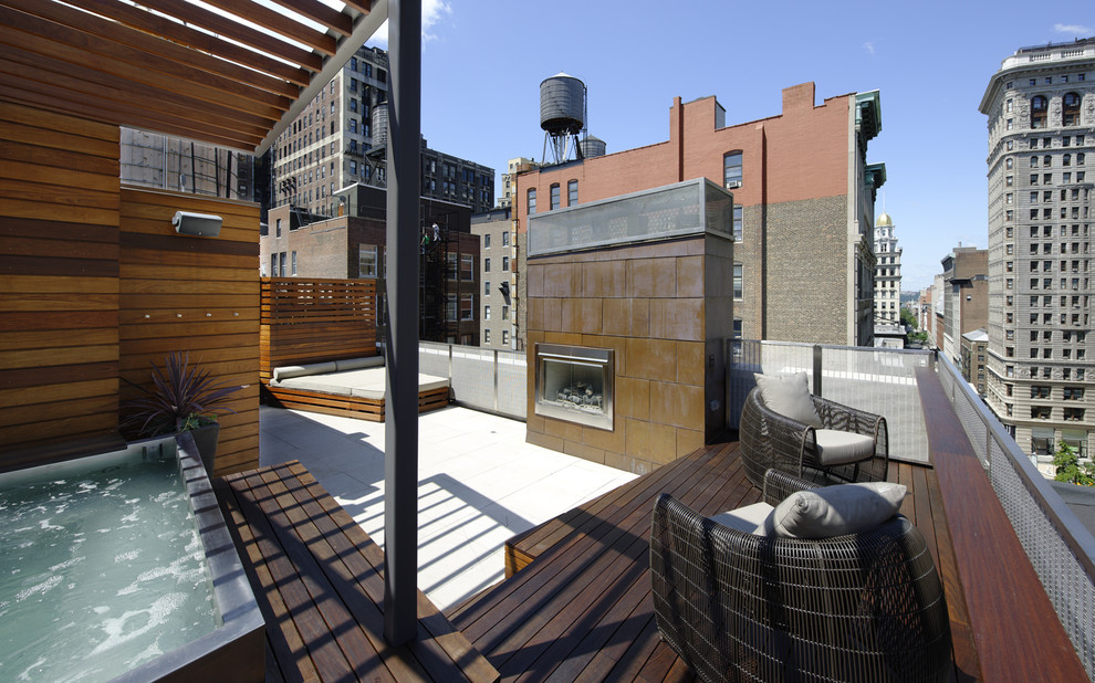 This is an example of an expansive contemporary patio in New York with a fire feature.