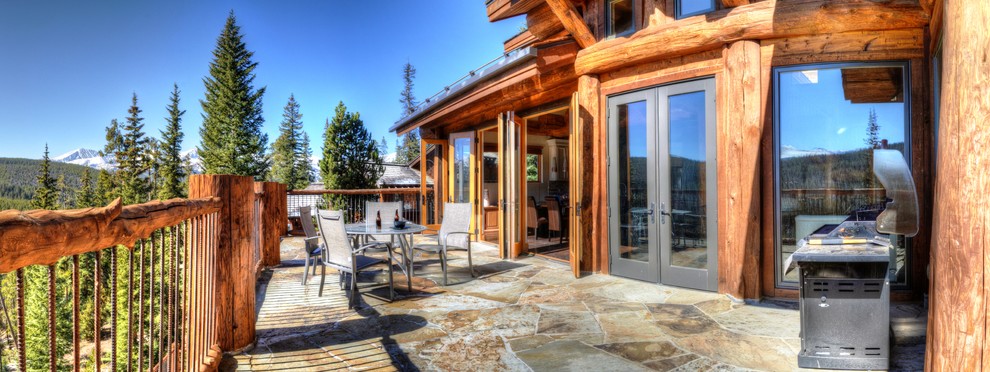 Example of a large mountain style backyard deck design with no cover