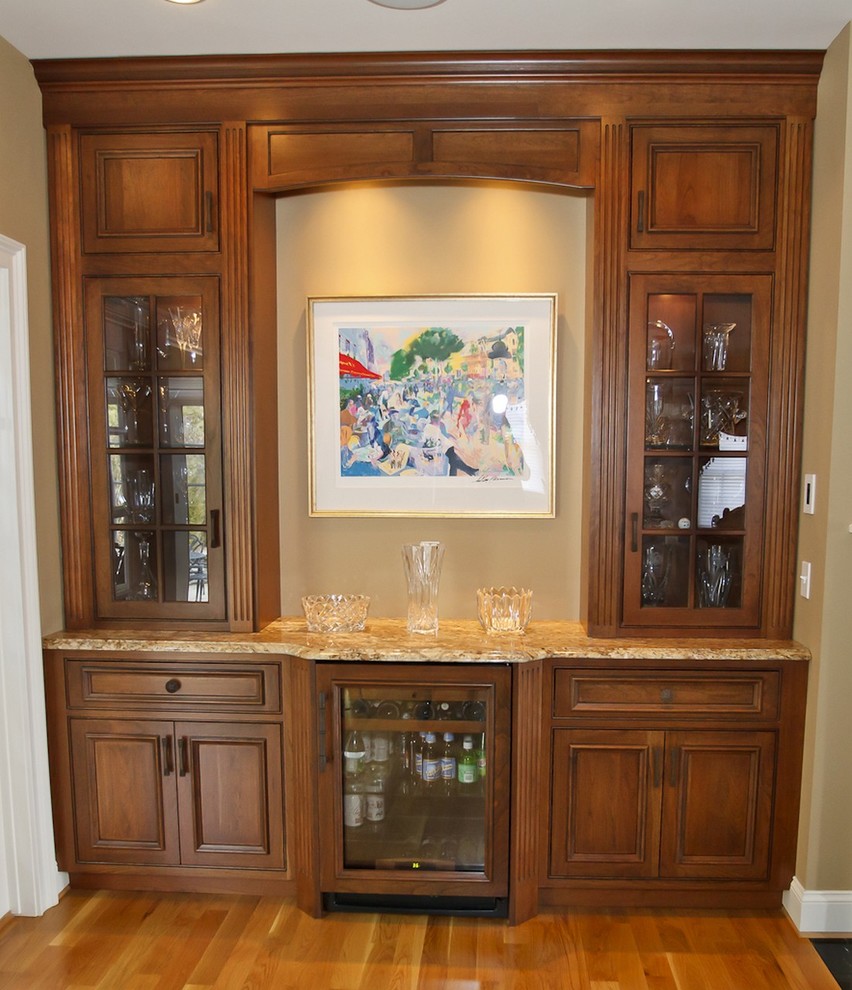 Photo of a mid-sized traditional single-wall wet bar in Boston with no sink, recessed-panel cabinets, dark wood cabinets, granite benchtops and medium hardwood floors.