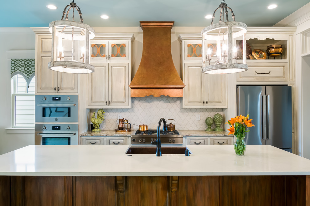 Photo of a country galley eat-in kitchen in Louisville with raised-panel cabinets, distressed cabinets, white splashback, stainless steel appliances and with island.