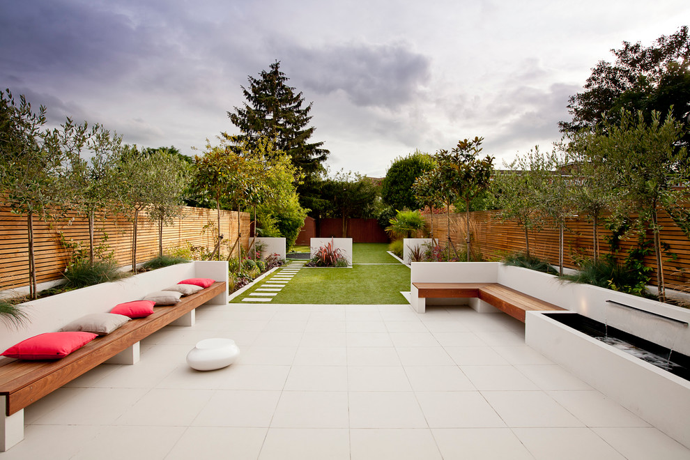 Photo of a mid-sized contemporary backyard patio in London with a water feature, tile and no cover.