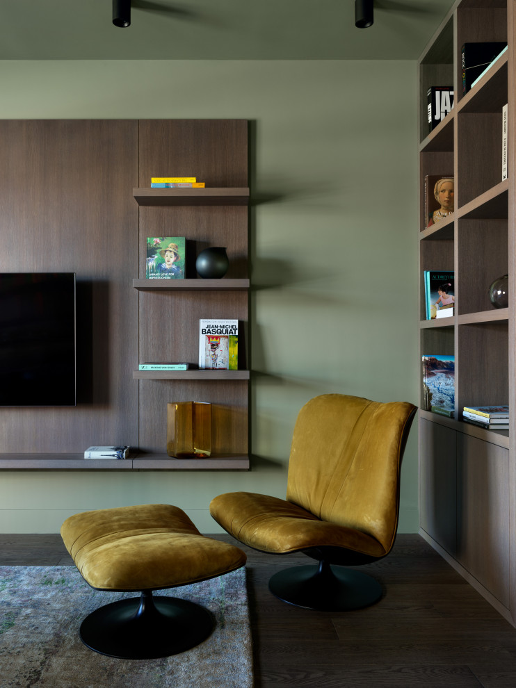 Стильный дизайн: большая открытая гостиная комната в современном стиле с зелеными стенами, темным паркетным полом, телевизором на стене и коричневым полом - последний тренд