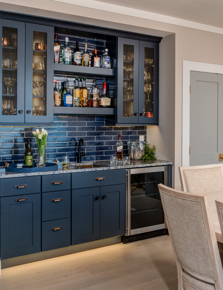 Photo of a beach style home bar in Other with blue cabinets.