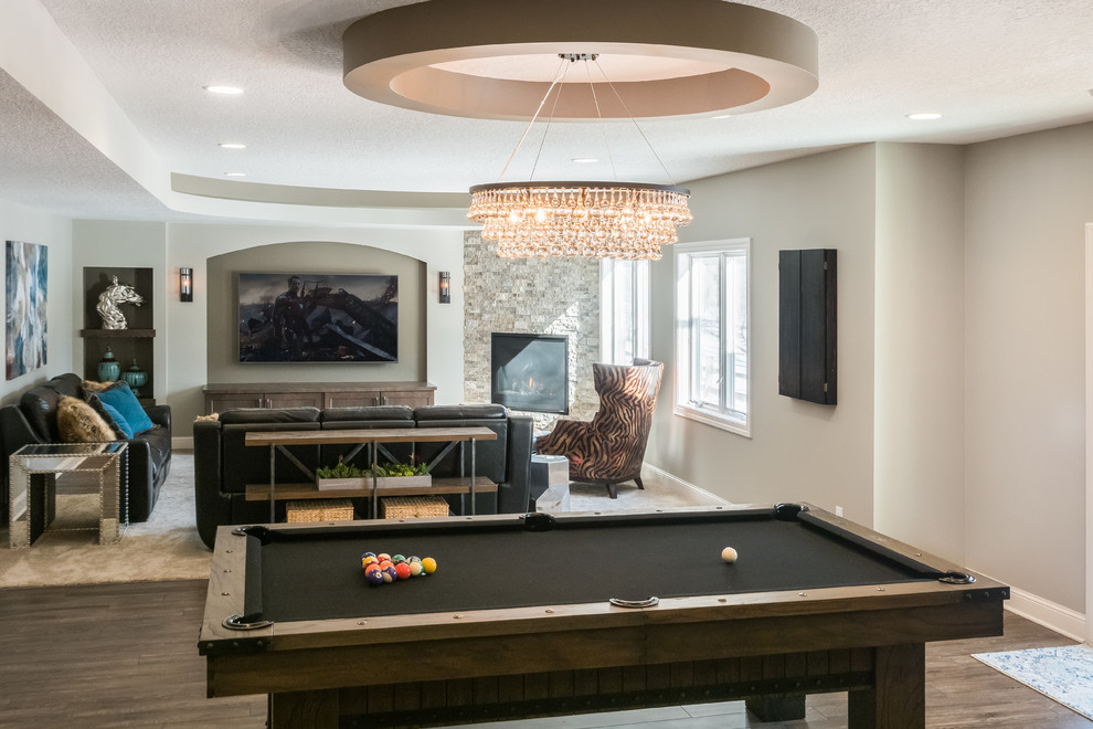 This is an example of a mid-sized contemporary walk-out basement in Minneapolis with beige walls, a corner fireplace, a tile fireplace surround and brown floor.