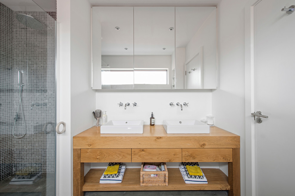 Inspiration for a contemporary 3/4 bathroom in Dublin with open cabinets, medium wood cabinets, white walls and wood benchtops.