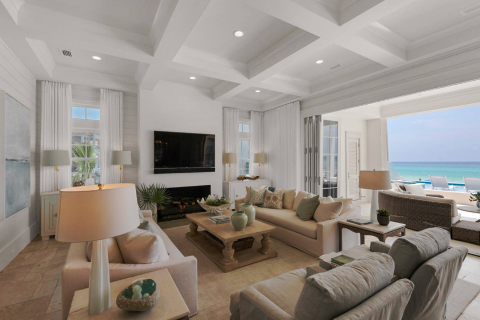 Large beach style formal open concept living room in DC Metro with white walls, a standard fireplace, a wall-mounted tv, beige floor, travertine floors and a plaster fireplace surround.