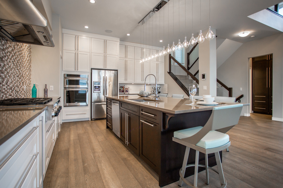 Example of a large minimalist light wood floor kitchen design with an island