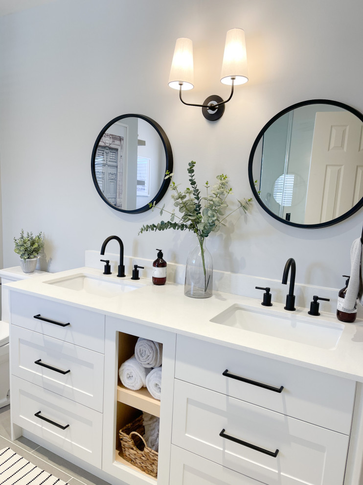 Inspiration for a mid-sized contemporary master black and white tile double-sink bathroom remodel in Toronto with raised-panel cabinets, white cabinets, a drop-in sink, quartzite countertops, a hinged shower door, gray countertops and a floating vanity
