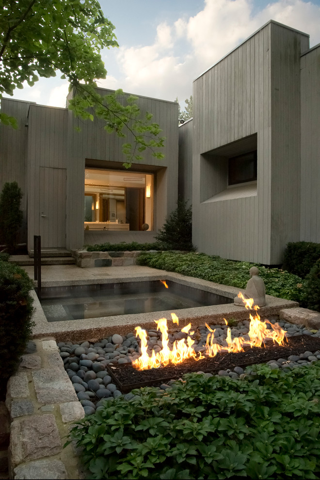 Contemporary partial sun garden in Detroit with a fire feature.