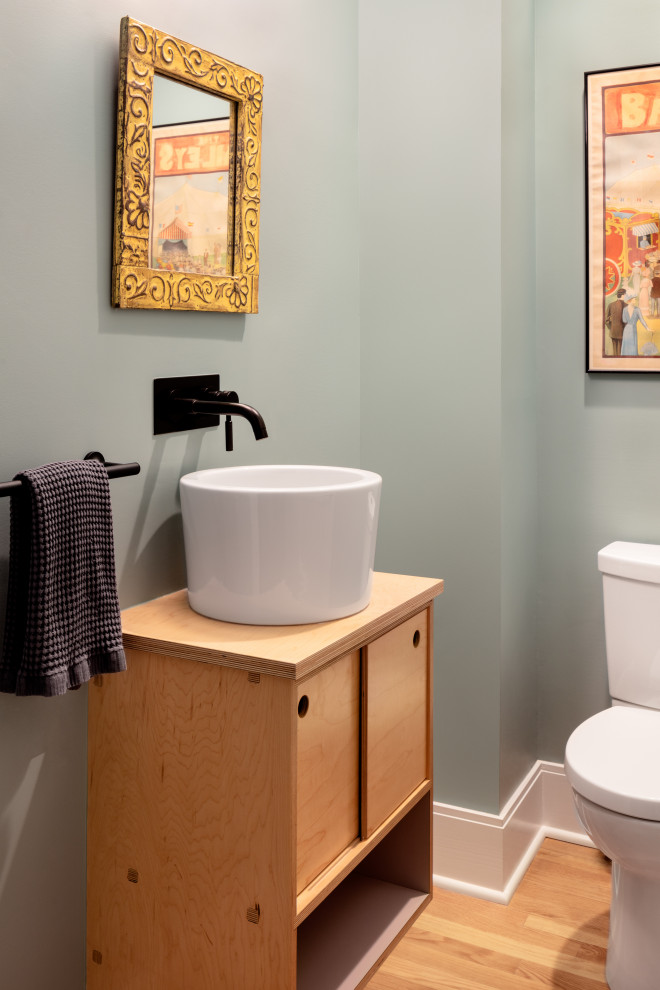 Photo of a powder room in DC Metro with flat-panel cabinets, brown cabinets, a two-piece toilet, medium hardwood floors, a vessel sink, wood benchtops, brown floor, brown benchtops and a built-in vanity.