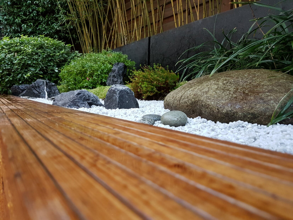 Inspiration for a small asian backyard patio in Paris with a water feature, decking and no cover.