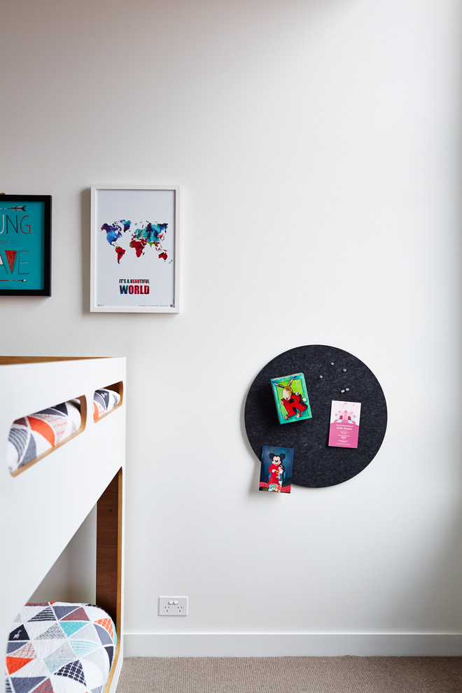 This is an example of a mid-sized gender-neutral kids' bedroom in Melbourne with white walls and carpet.