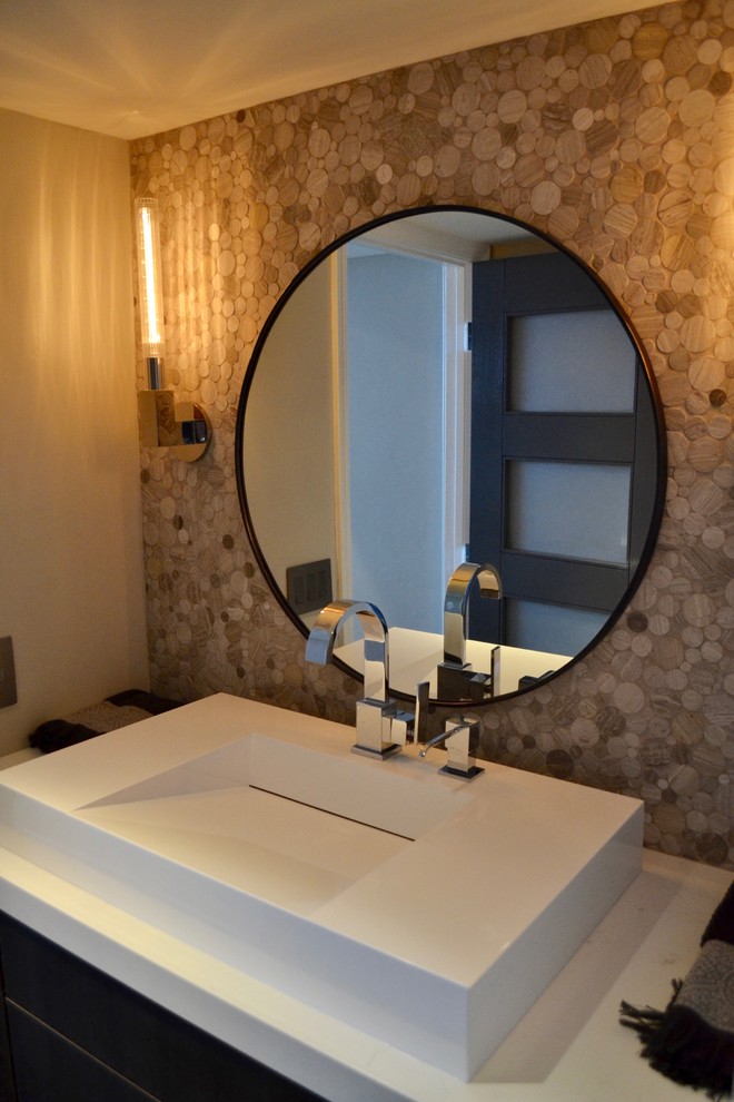Inspiration for a small contemporary powder room in Orange County with flat-panel cabinets, brown cabinets, a one-piece toilet, beige tile, pebble tile, grey walls, medium hardwood floors, a pedestal sink, engineered quartz benchtops and grey floor.