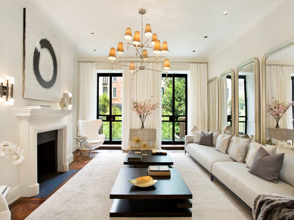 This is an example of a transitional formal living room in New York with white walls, dark hardwood floors and a standard fireplace.