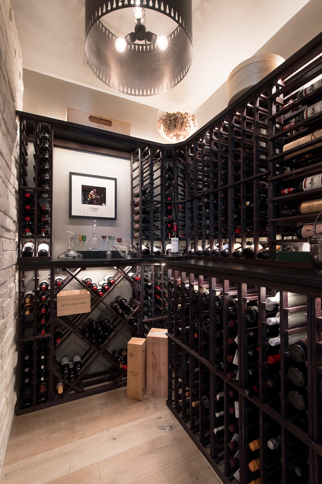 Contemporary wine cellar in Austin with light hardwood floors, diamond bins and beige floor.