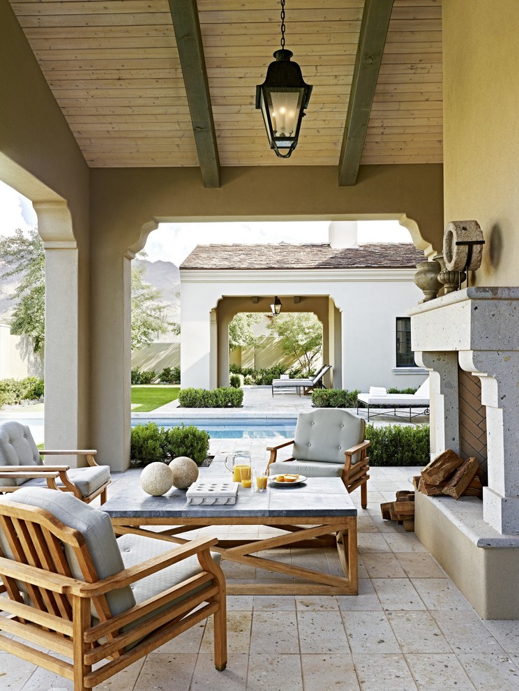 Photo of a mediterranean patio in Los Angeles with a fire feature and a roof extension.
