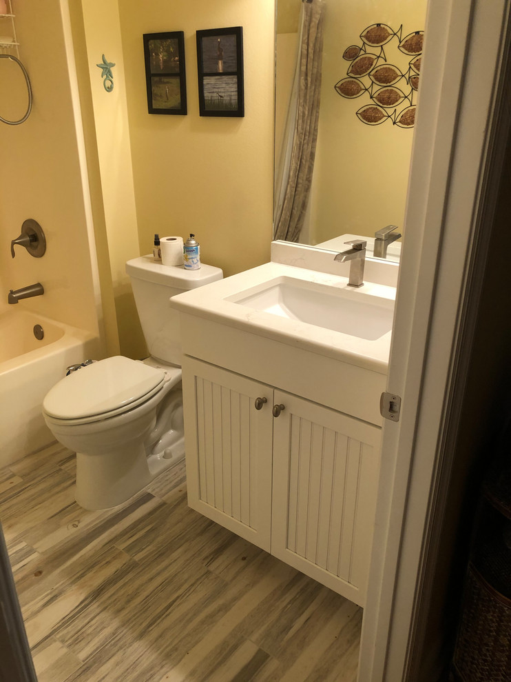 Small beach style kids bathroom in Other with beaded inset cabinets, white cabinets, yellow walls, porcelain floors, an undermount sink, engineered quartz benchtops, multi-coloured floor, a shower curtain and white benchtops.
