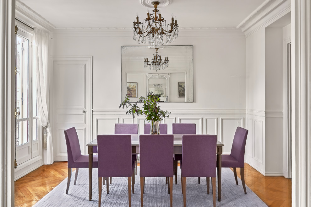 Design ideas for a transitional separate dining room in Paris with white walls, medium hardwood floors, brown floor and decorative wall panelling.