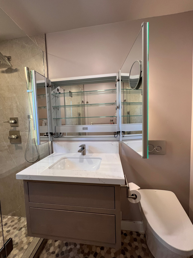 Photo of a small contemporary master bathroom in Sacramento with flat-panel cabinets, light wood cabinets, a wall-mount toilet, gray tile, ceramic tile, purple walls, pebble tile floors, an undermount sink, engineered quartz benchtops, multi-coloured floor, a hinged shower door, white benchtops, a shower seat, a single vanity and a floating vanity.