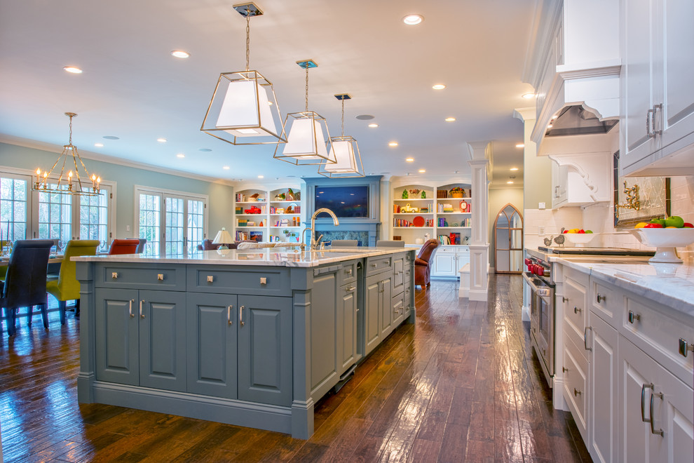 This is an example of a traditional l-shaped open plan kitchen in Boston with an undermount sink, raised-panel cabinets, white cabinets, medium hardwood floors and with island.