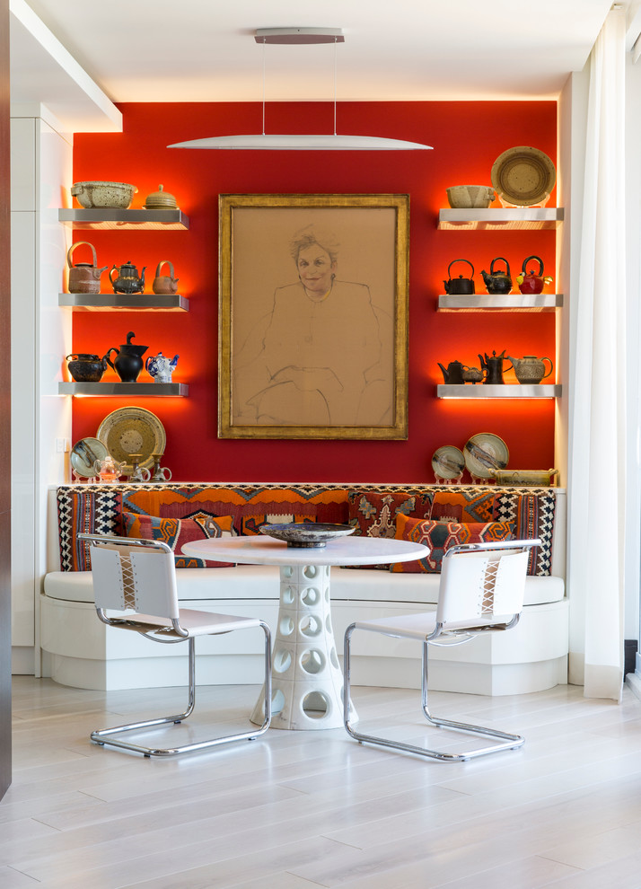 This is an example of an eclectic dining room in Miami with red walls, light hardwood floors and no fireplace.