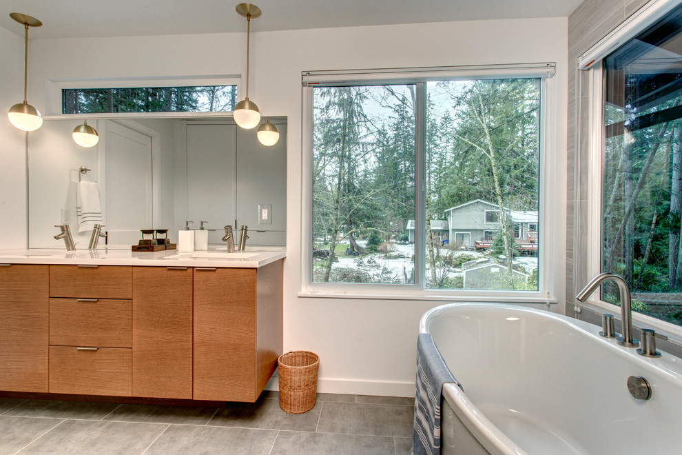 This is an example of a contemporary master bathroom in Seattle with flat-panel cabinets, a freestanding tub, a curbless shower, gray tile, white walls, ceramic floors, an undermount sink and engineered quartz benchtops.