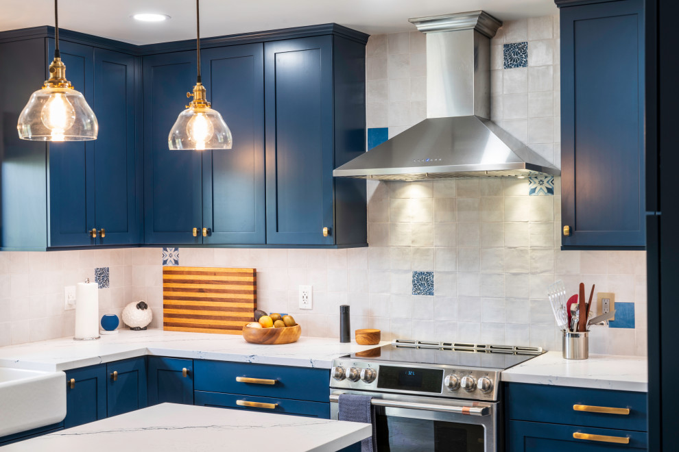 Design ideas for a large eclectic u-shaped eat-in kitchen in San Luis Obispo with a farmhouse sink, shaker cabinets, blue cabinets, quartz benchtops, white splashback, ceramic splashback, stainless steel appliances, porcelain floors, with island, beige floor and white benchtop.