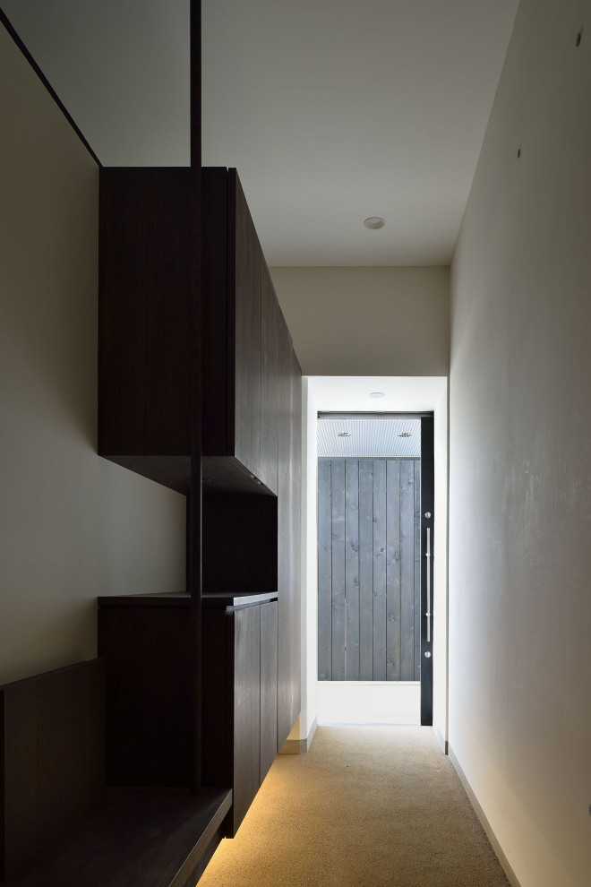 This is an example of a medium sized contemporary front door in Other with white walls, a sliding front door, a black front door, brown floors and a timber clad ceiling.
