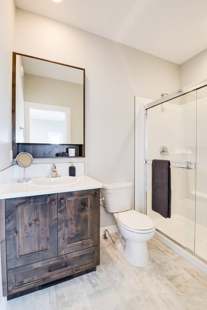 Mid-sized transitional bathroom photo with shaker cabinets, dark wood cabinets, a drop-in sink and laminate countertops
