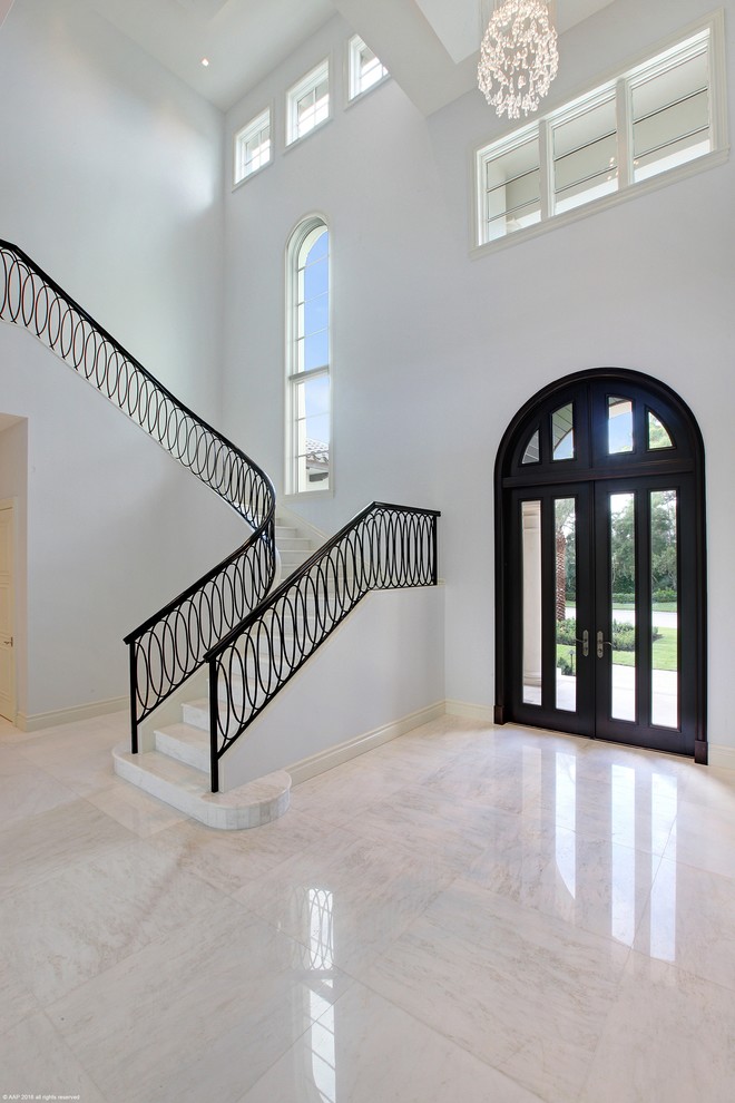 Photo of an expansive mediterranean foyer in Miami with white walls, marble floors, a double front door and a dark wood front door.