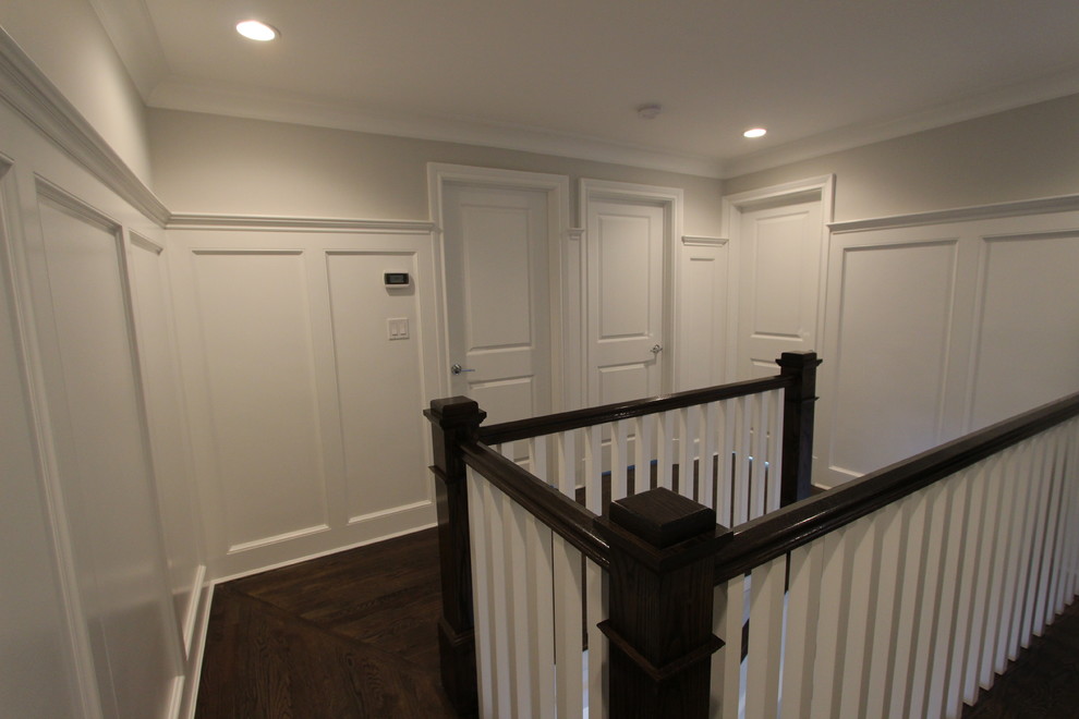 This is an example of a transitional hallway in New York with grey walls and dark hardwood floors.
