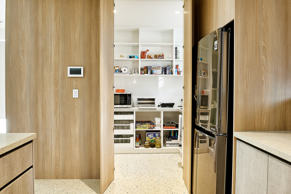 Foto på ett stort funkis grå kök, med en undermonterad diskho, släta luckor, grå skåp, bänkskiva i kvarts, brunt stänkskydd, stänkskydd i keramik, rostfria vitvaror, betonggolv och en köksö