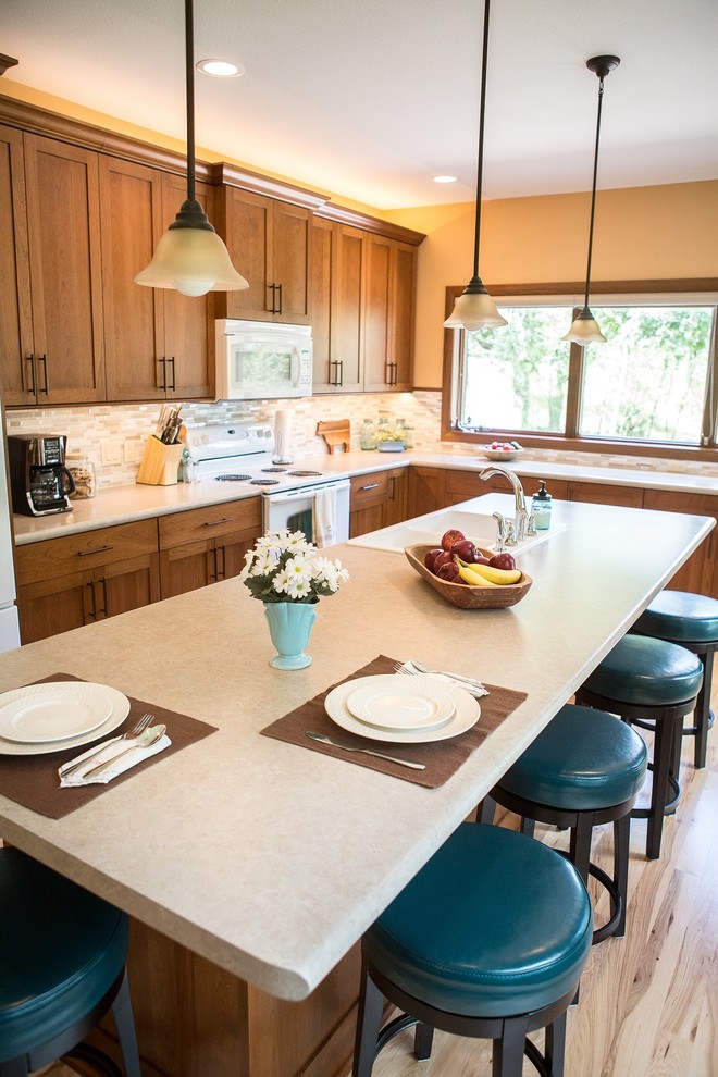 Example of a large transitional l-shaped light wood floor eat-in kitchen design in Cedar Rapids with a double-bowl sink, recessed-panel cabinets, medium tone wood cabinets, laminate countertops, multicolored backsplash, mosaic tile backsplash, white appliances and an island