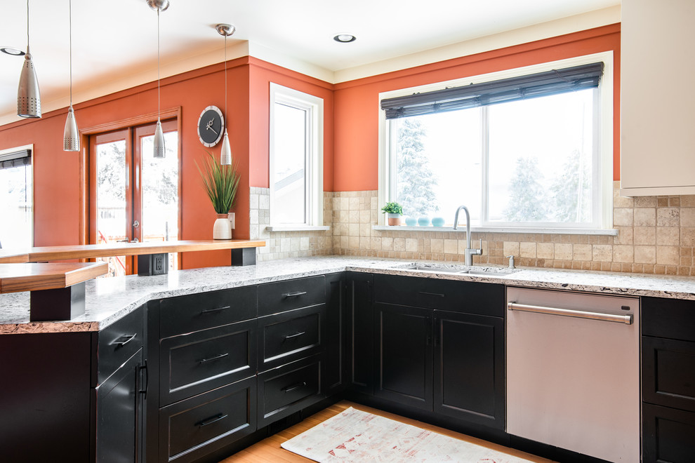 Example of a mid-sized transitional u-shaped medium tone wood floor and brown floor eat-in kitchen design with an undermount sink, shaker cabinets, distressed cabinets, quartz countertops, white backsplash, travertine backsplash, stainless steel appliances, a peninsula and multicolored countertops