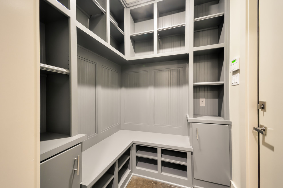 Mudroom - mid-sized transitional concrete floor mudroom idea in Houston with white walls and a white front door