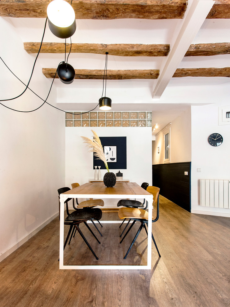 This is an example of a contemporary open plan dining in Barcelona with white walls, light hardwood floors and no fireplace.