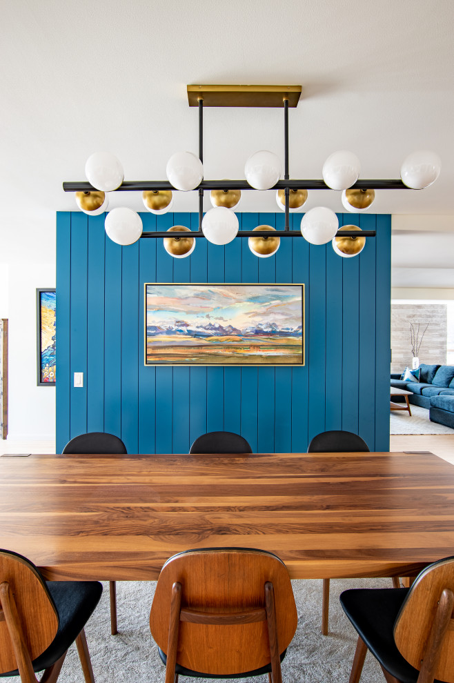 Imagen de comedor de cocina retro de tamaño medio con paredes azules, suelo de madera clara y machihembrado