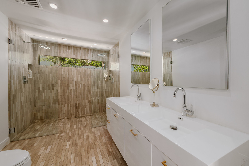 Design ideas for a large mediterranean 3/4 wet room bathroom in Los Angeles with white walls, flat-panel cabinets, a one-piece toilet, an integrated sink and an open shower.