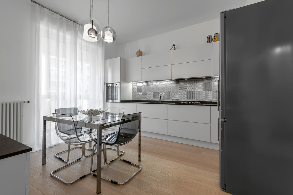 Mid-sized contemporary kitchen in Milan with ceramic floors and beige floor.