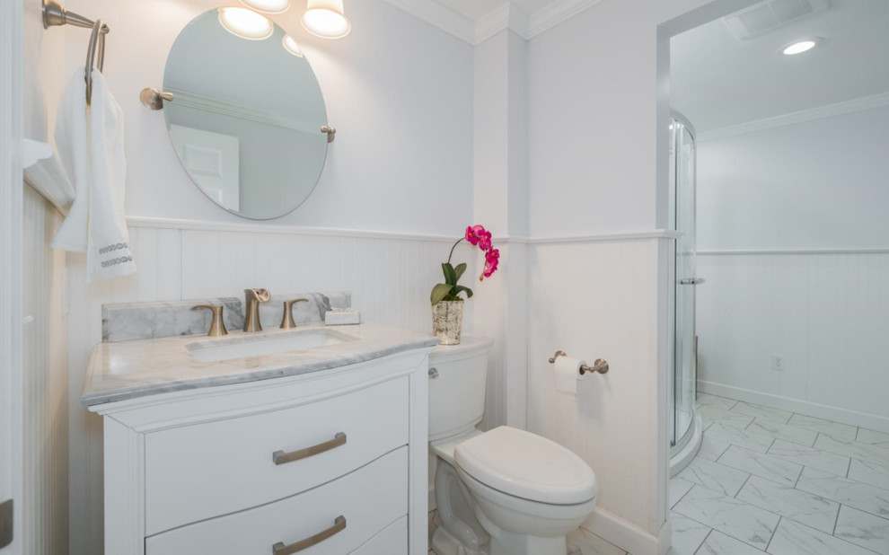 Mid-sized transitional master bathroom in New York with furniture-like cabinets, white cabinets, a double shower, a two-piece toilet, white tile, porcelain tile, porcelain floors, an undermount sink and granite benchtops.