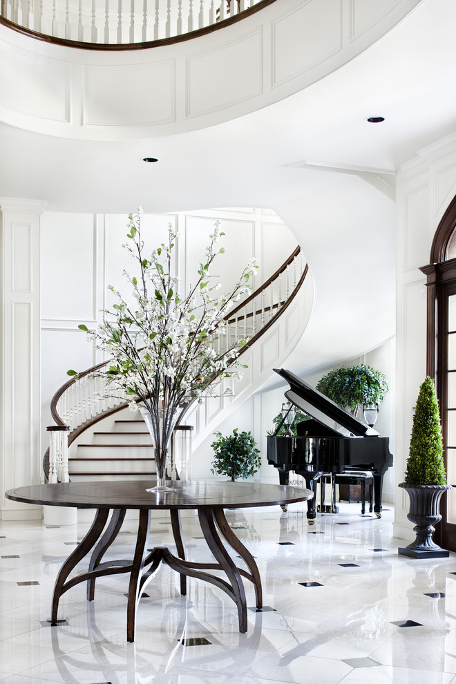 Expansive traditional foyer in Austin with white walls and marble floors.